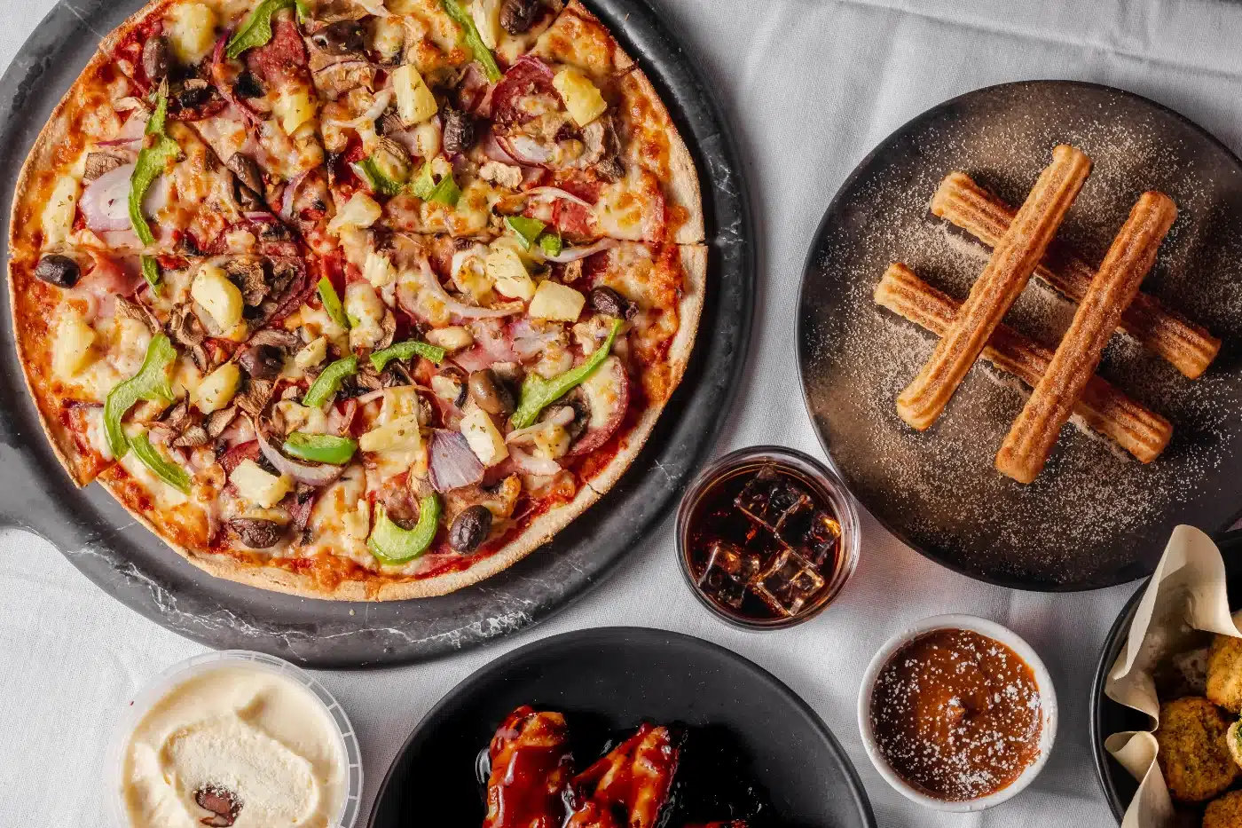 I Love Pizza box on a timber table with basil and a slice