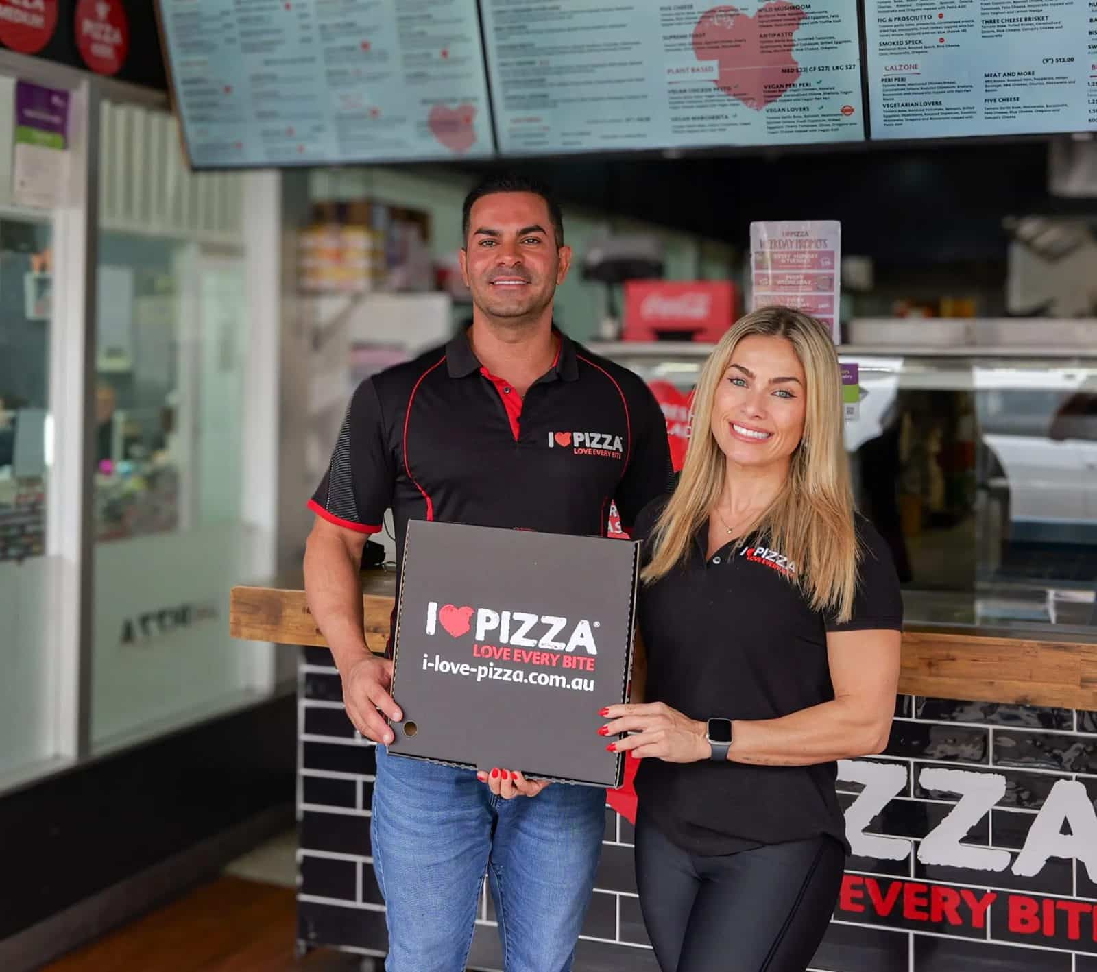 I Love Pizza founders Thiago and Roberta holding a pizza box in the Balgowlah store