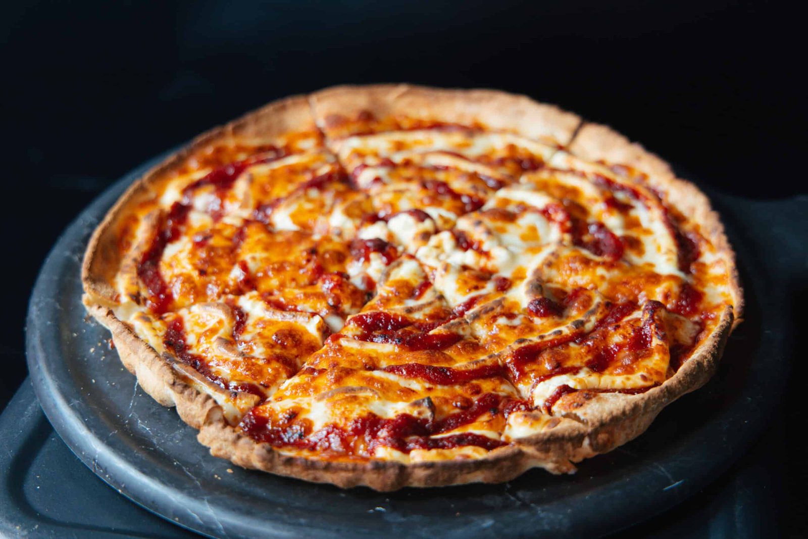 Thin-crust pizza on a slate board