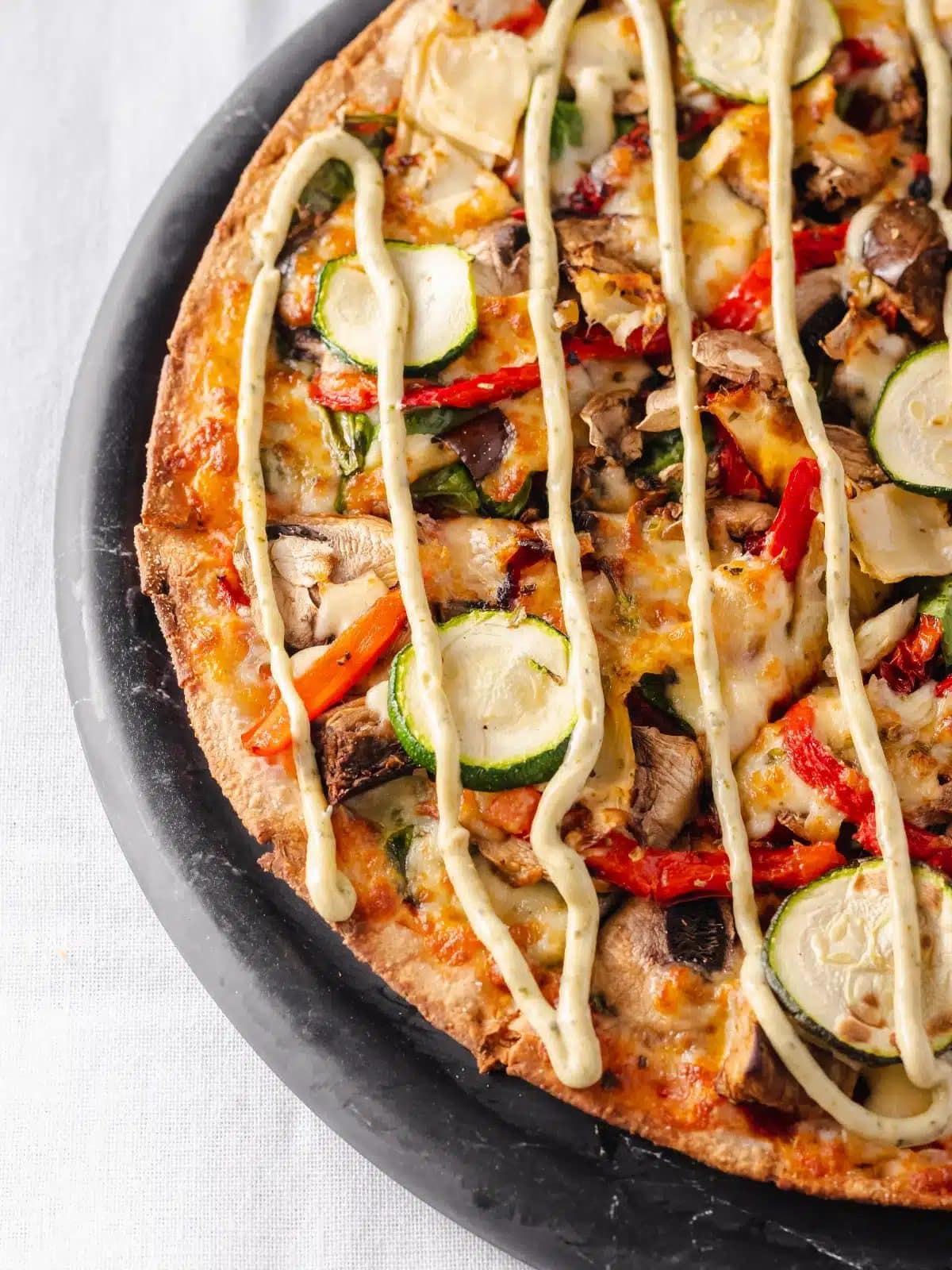 Vegetarian pizza with roasted vegetables and aioli drizzle